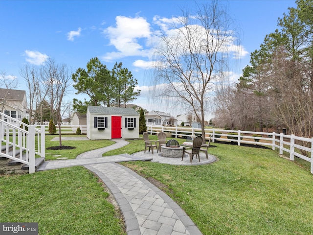 view of yard with an outdoor fire pit and a storage unit