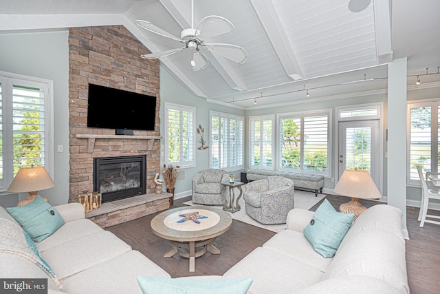 living room with lofted ceiling with beams, a stone fireplace, hardwood / wood-style flooring, and ceiling fan