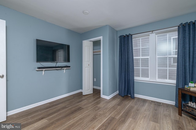 bedroom with hardwood / wood-style floors and a closet