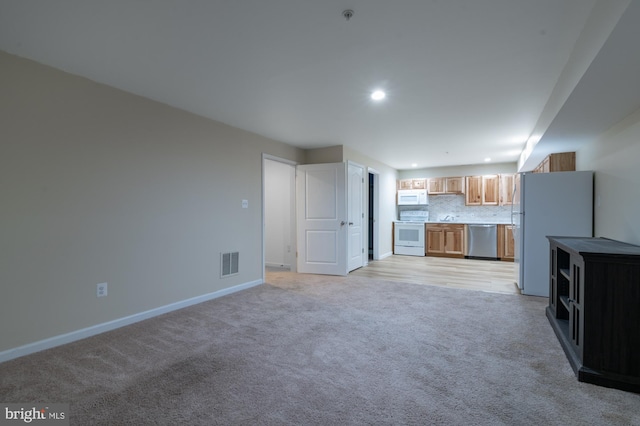 unfurnished living room featuring light colored carpet