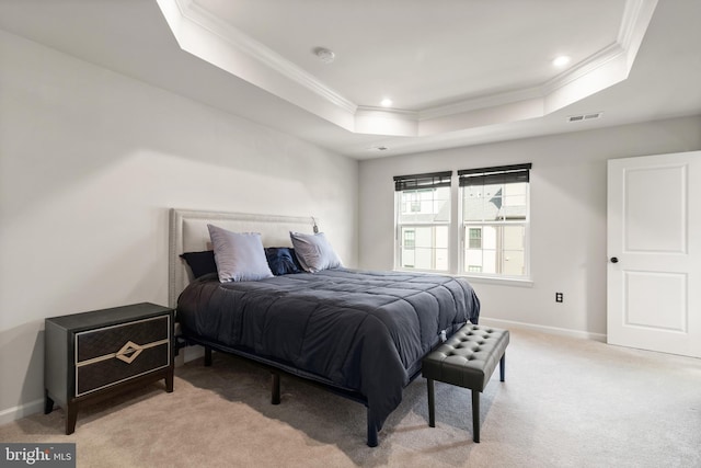 bedroom with light colored carpet, a tray ceiling, and ornamental molding