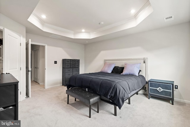 carpeted bedroom featuring ornamental molding and a tray ceiling