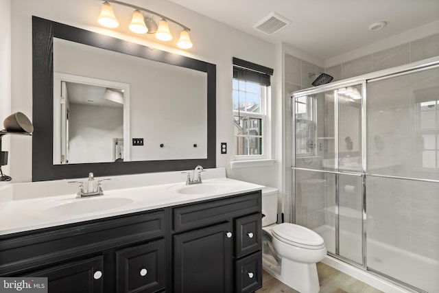 bathroom featuring toilet, a shower with door, wood-type flooring, and vanity