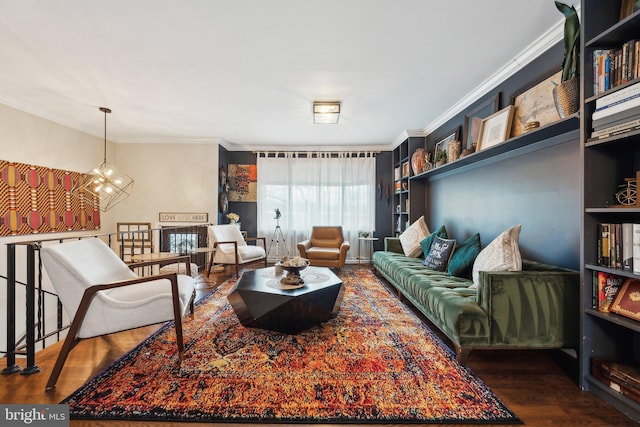 living room featuring a chandelier, dark wood-type flooring, and ornamental molding