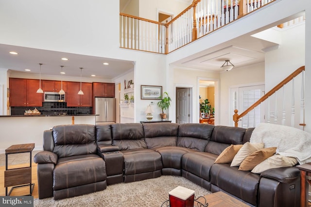 living room with a high ceiling, crown molding, and hardwood / wood-style floors