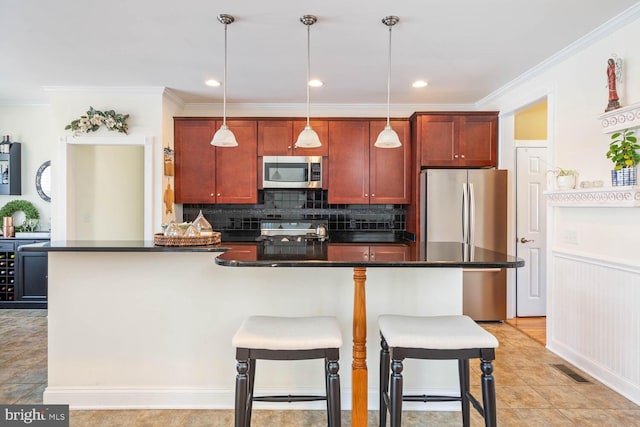 kitchen with hanging light fixtures, crown molding, stainless steel appliances, and a kitchen bar