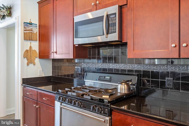 kitchen featuring dark stone countertops, decorative backsplash, and appliances with stainless steel finishes