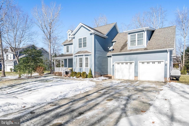 view of property with a porch and a garage