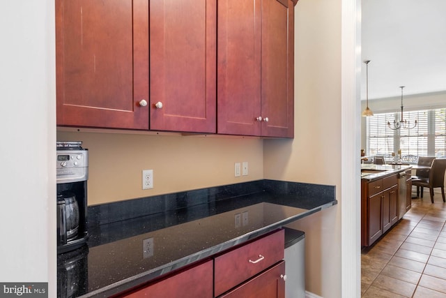 kitchen featuring dark stone countertops, tile patterned floors, an inviting chandelier, and decorative light fixtures