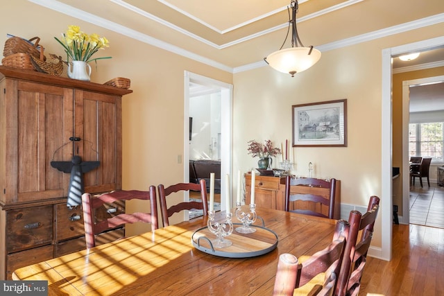 dining area featuring ornamental molding and dark hardwood / wood-style floors