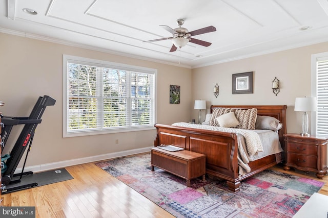 bedroom with crown molding, light hardwood / wood-style flooring, and ceiling fan