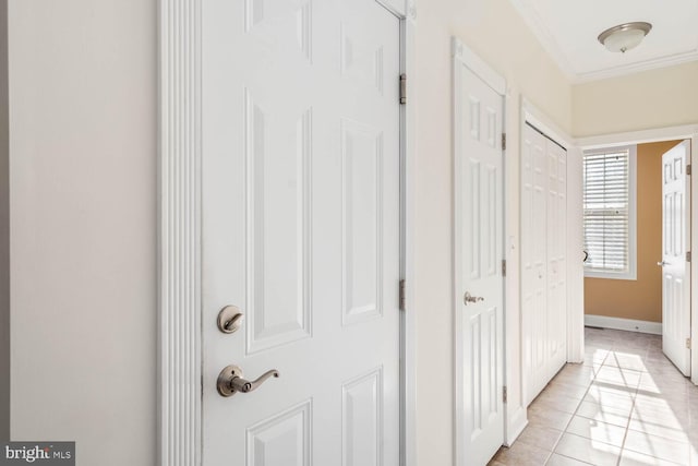 hallway featuring crown molding and light tile patterned flooring