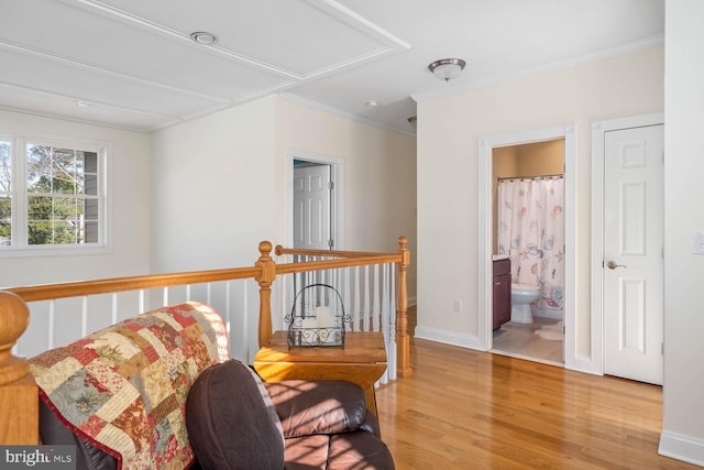 living area featuring crown molding and light hardwood / wood-style floors