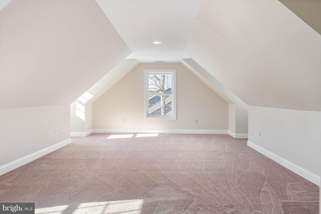 bonus room with light carpet and vaulted ceiling