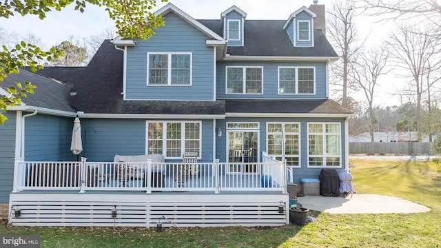 rear view of house with a yard and a deck