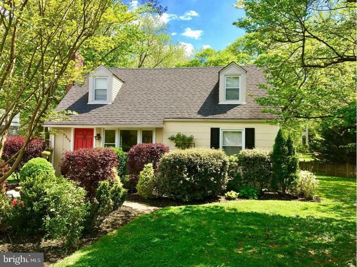 new england style home featuring a front lawn