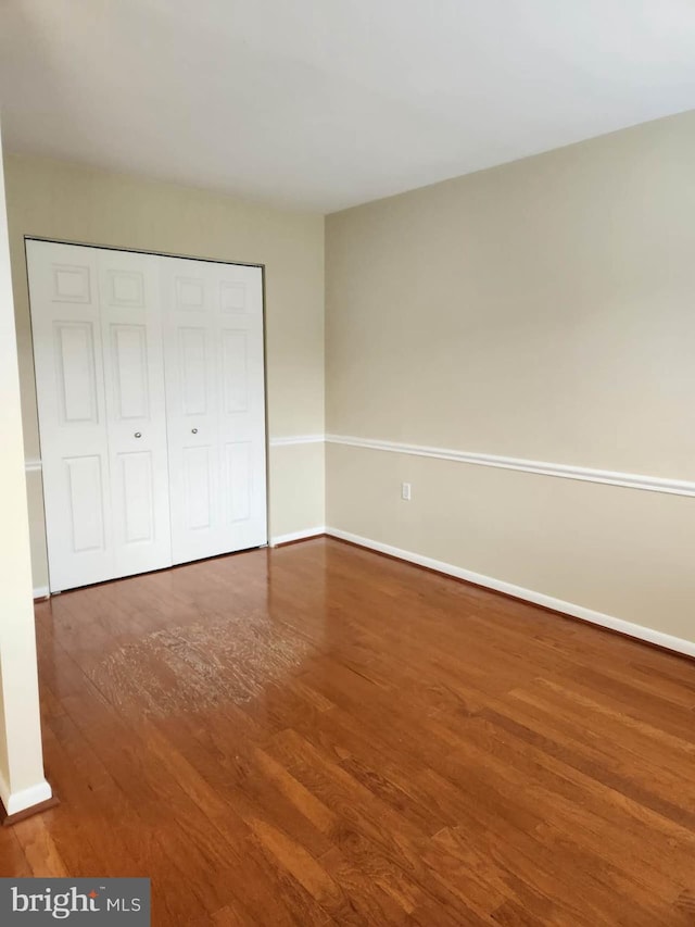 unfurnished bedroom with a closet and wood-type flooring