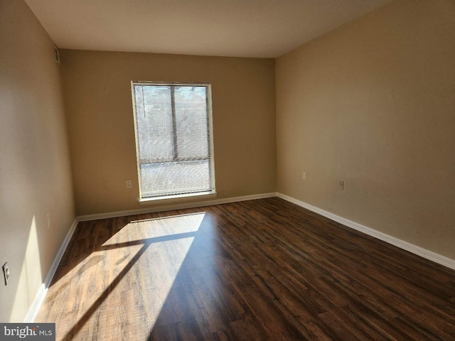 unfurnished room with dark wood-type flooring