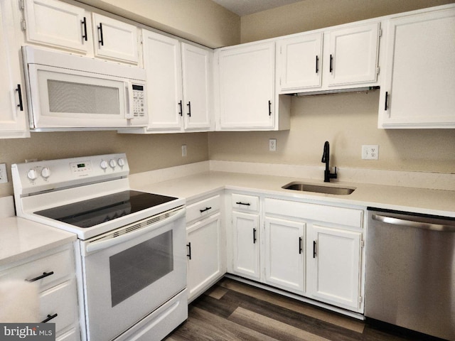 kitchen with sink, white appliances, white cabinets, and dark hardwood / wood-style flooring