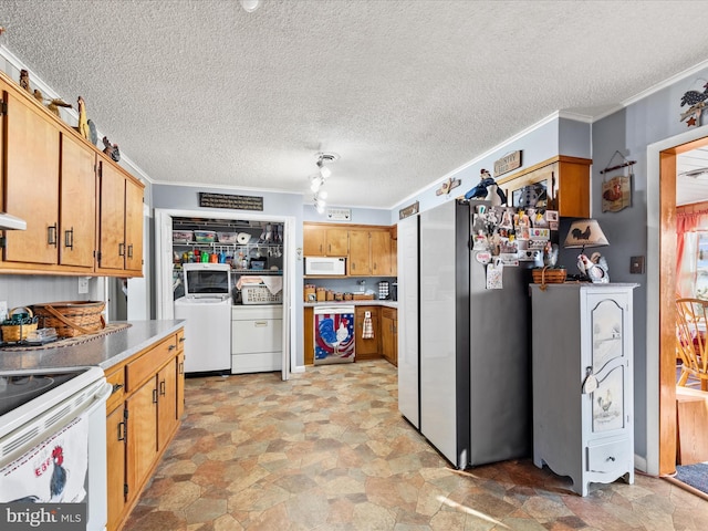 kitchen featuring white appliances, ornamental molding, and washing machine and dryer