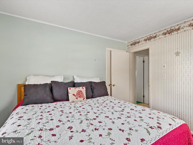 bedroom featuring a textured ceiling and crown molding