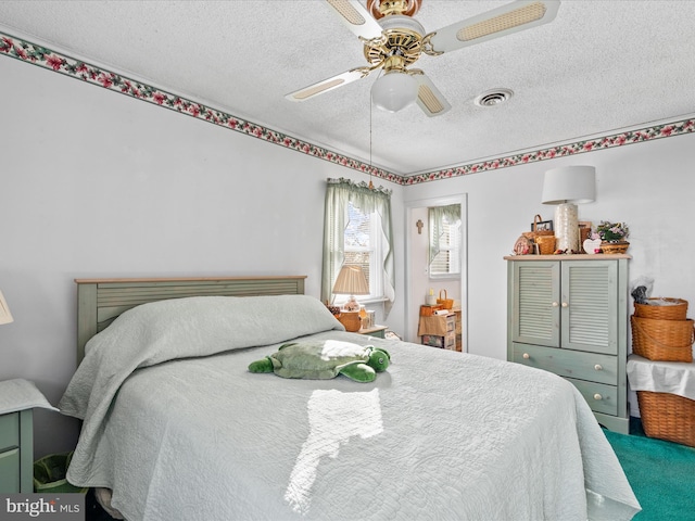 bedroom with ceiling fan and a textured ceiling