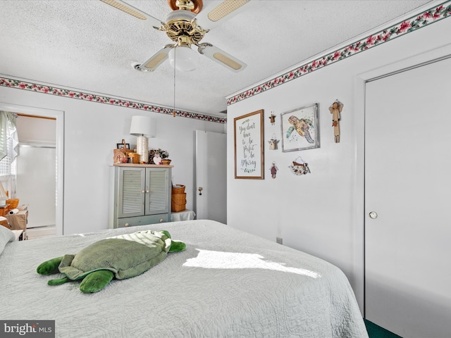 bedroom with ceiling fan and a textured ceiling