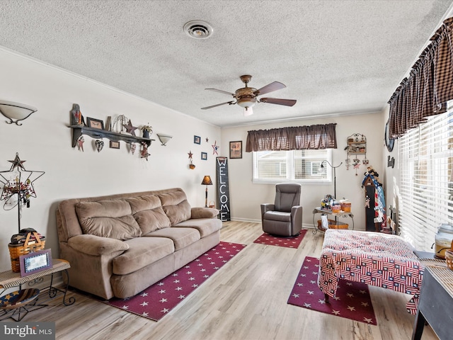 living room featuring ceiling fan, a textured ceiling, and light hardwood / wood-style floors