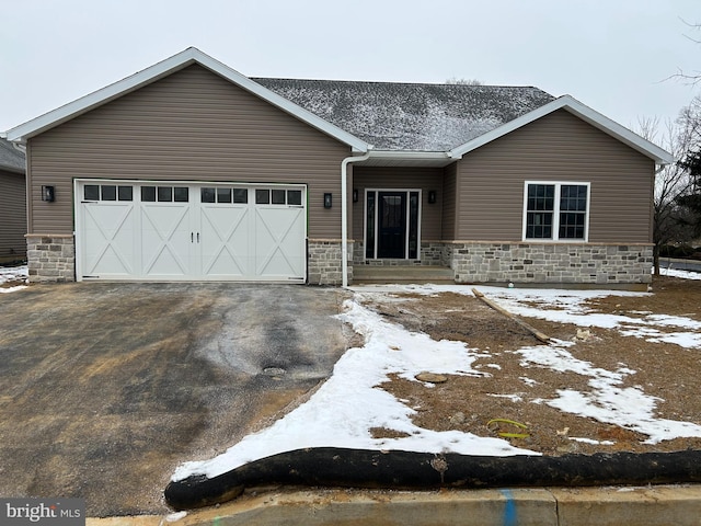 view of front of house with stone siding, aphalt driveway, and an attached garage