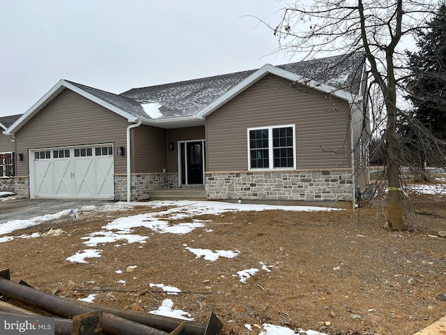 view of front of property with a garage, stone siding, and aphalt driveway