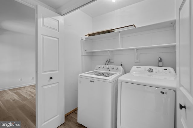 laundry room with light hardwood / wood-style flooring and washing machine and dryer