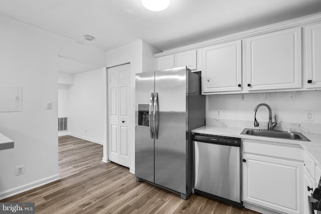 kitchen featuring white cabinets, hardwood / wood-style floors, appliances with stainless steel finishes, and sink