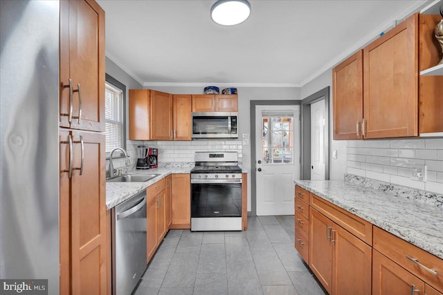 kitchen with tasteful backsplash, sink, crown molding, stainless steel appliances, and light stone counters