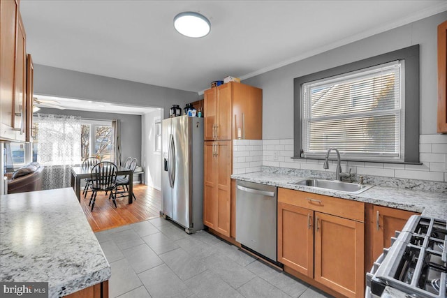 kitchen featuring light tile patterned floors, stainless steel appliances, backsplash, light stone countertops, and sink