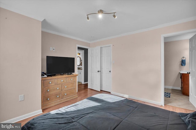 bedroom featuring light wood-type flooring, a closet, and ornamental molding