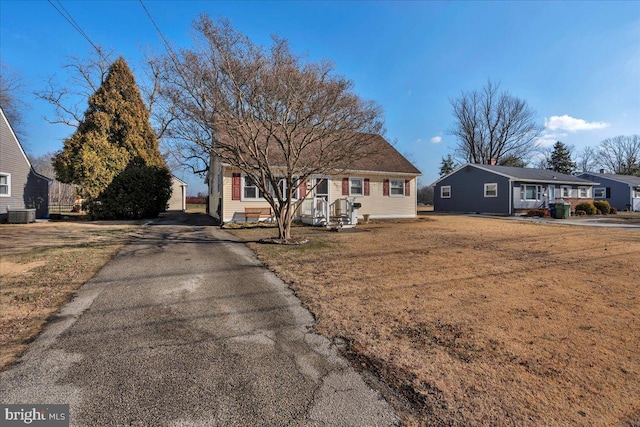 view of front of house with a front yard and central air condition unit