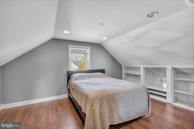 bedroom with dark wood-type flooring and lofted ceiling