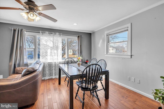 dining space with ceiling fan, ornamental molding, and wood-type flooring