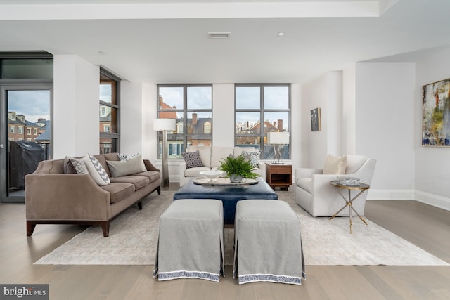 living room featuring baseboards, visible vents, and wood finished floors