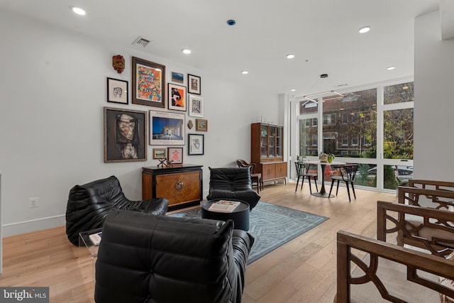 living room featuring light wood-type flooring and floor to ceiling windows