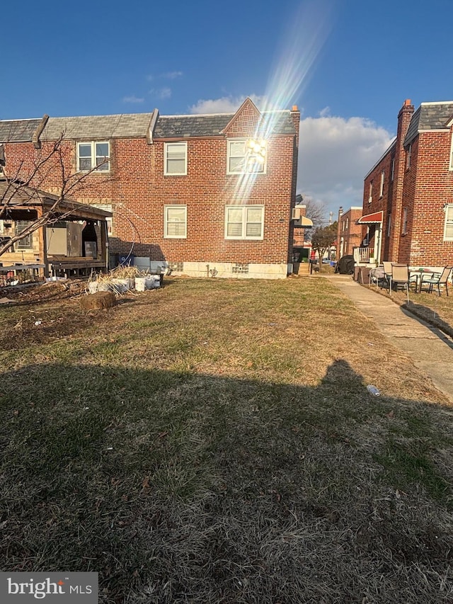 rear view of property with a lawn