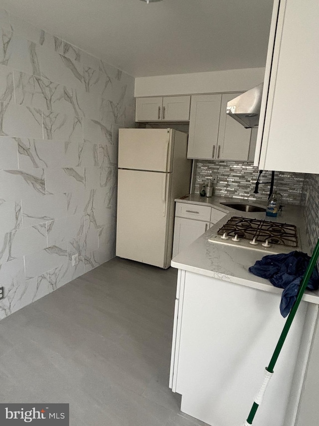 kitchen featuring sink, white appliances, decorative backsplash, and white cabinets