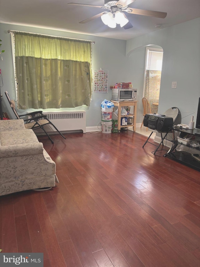 living area featuring ceiling fan, radiator, and hardwood / wood-style floors