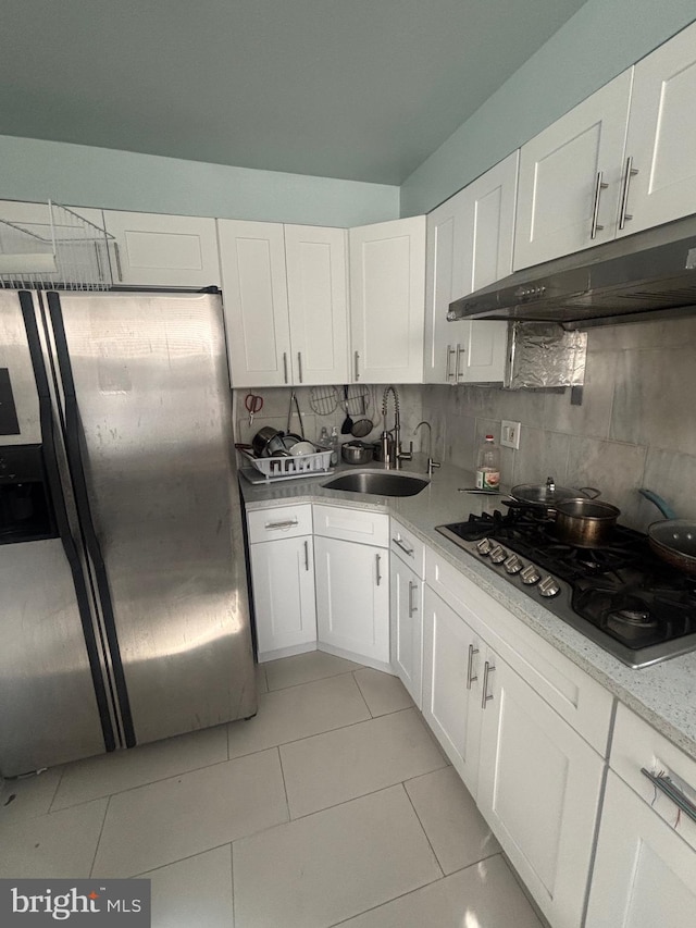 kitchen with appliances with stainless steel finishes, sink, white cabinets, and decorative backsplash