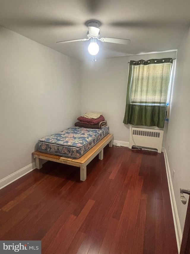 bedroom featuring radiator, dark wood-type flooring, and ceiling fan