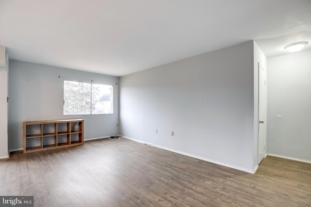 empty room with baseboards and wood finished floors