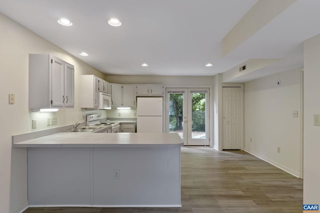 kitchen featuring white appliances, white cabinets, sink, kitchen peninsula, and light wood-type flooring