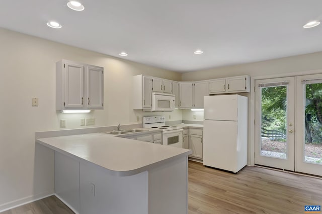 kitchen featuring white cabinetry, white appliances, kitchen peninsula, and light wood-type flooring