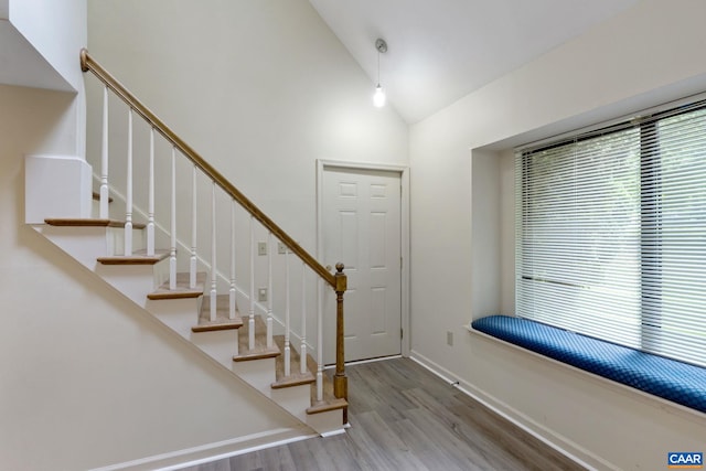 foyer entrance with lofted ceiling and hardwood / wood-style floors