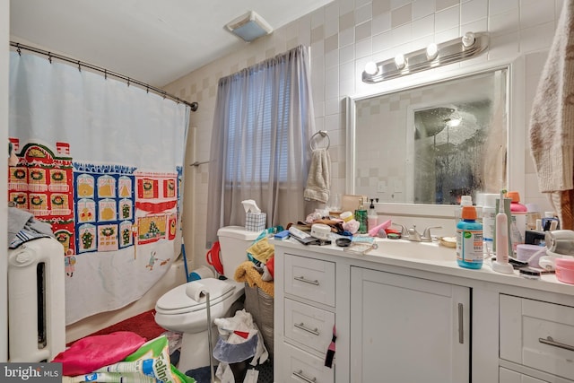 full bathroom with shower / tub combo with curtain, vanity, toilet, and tile walls